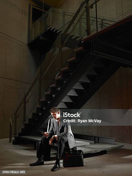 Junger Geschäftsmann Sitzen Auf Bank Am Treppe Mit Handy Uhr Stockfoto und mehr Bilder von Geschäftsmann
