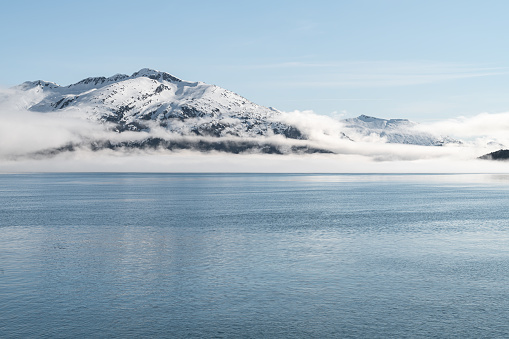 View from the ferry of the frozen morning fog above the fjord with snowcapped mountain view in Norway