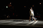 Young man and woman crossing street at night, side view