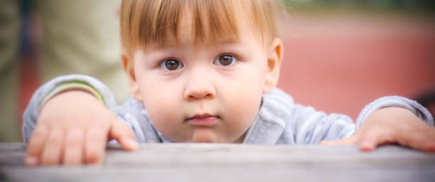 istock Curious Little Boy Leaning Over a Mystical Table of Wonder 2004814436