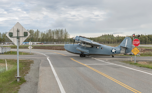 Grumman G-21 JRF OA-9 OA-13 Goose Float plane crossing a road at Anchorage airport, Anchorage, Alaska, USA