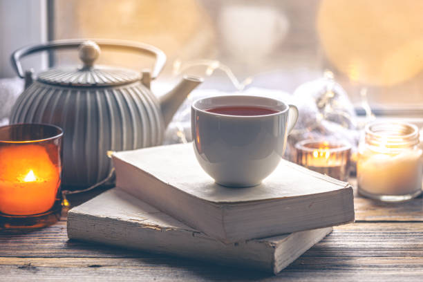 istock Cozy composition with books and a cup of tea by the window. 2004823907