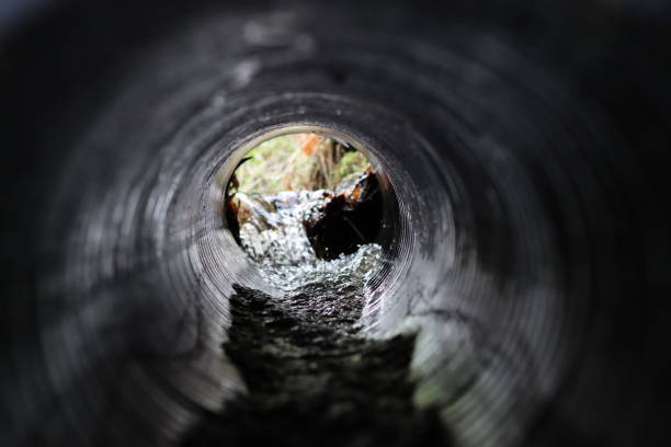 istock View through a round tunnel carrying a stream beneath a road 2004833151
