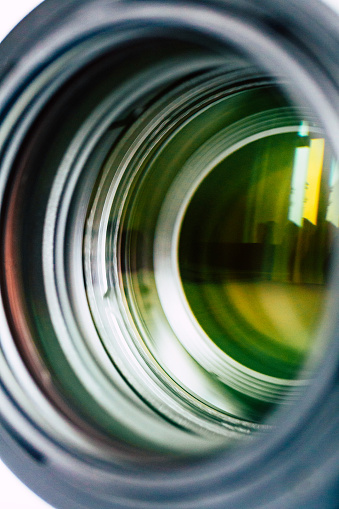 Abstract macro image depicting reflection and refraction on the front glass element of a camera lens.