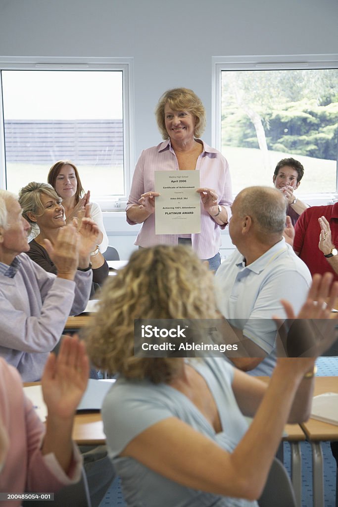 Grupo aplaudir Mulher a segurar certificado de educação e formação de adultos cl - Royalty-free Aplaudir Foto de stock