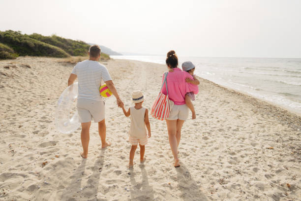 istock Young family walking down the beach 2004861188