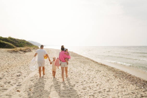 istock Young family walking down the beach 2004861710