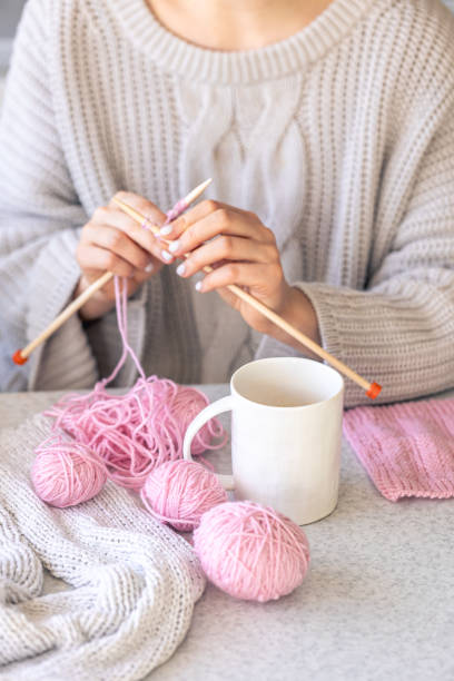 istock A woman knits and drinks coffee, winter hobby concept. 2004862785