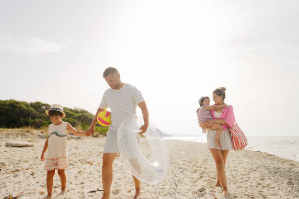 istock Young family walking down the beach 2004863318