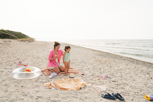 Photo of a mom applying sunscreen lotion on her daughter