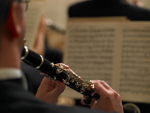 männliche clarinetist performing im orchester, nahaufnahme, von hinten - notenständer fotos stock-fotos und bilder