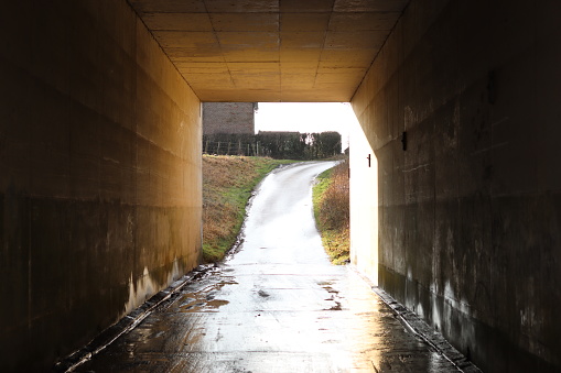 Sunlight shining through an underpass beneath a road