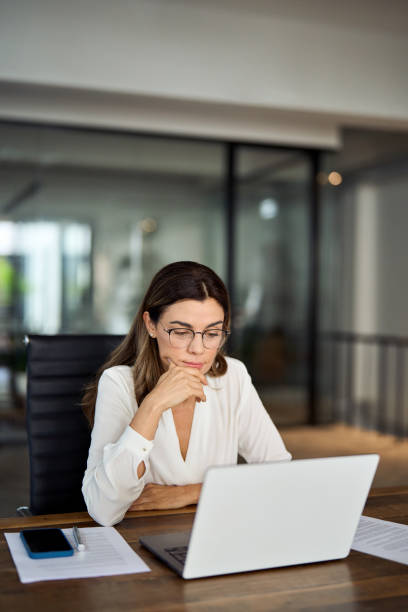 istock Busy mature business woman working in office using laptop thinking. 2004890519