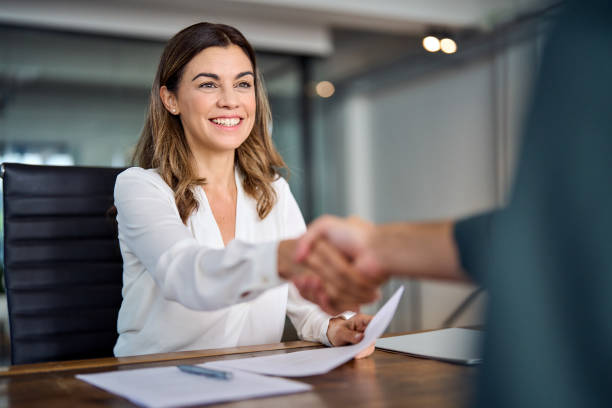 happy mid aged business woman manager handshaking at office meeting. - atendimento imagens e fotografias de stock