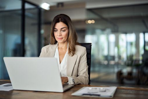 Shot of a young businesswoman writing in a notebook at her desk in a modern office