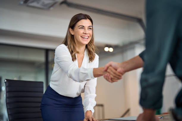 happy mid aged business woman manager handshaking greeting client in office. - 2603 imagens e fotografias de stock