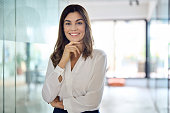 Happy confident Latin professional mid aged business woman in office, portrait.