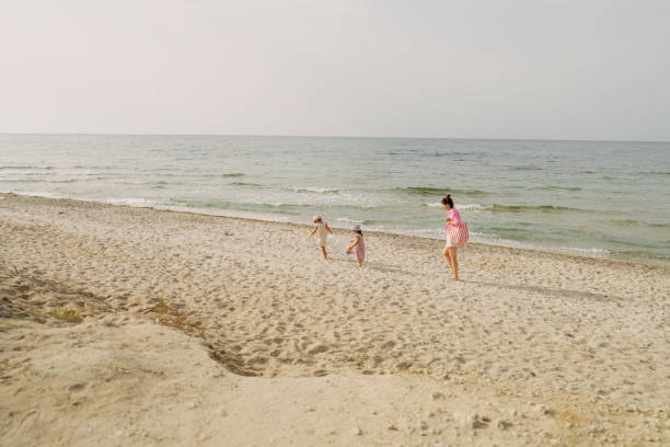 Family members enjoy a fun and relaxing day at the beach, playing with water guns in the shallow ocean waters, encapsulating the essence of summer joy and togetherness.