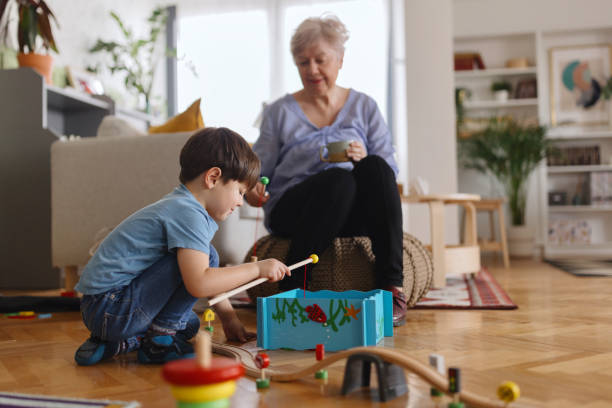 Portrait of a child grandson with grandparents having fun together playing board games at home