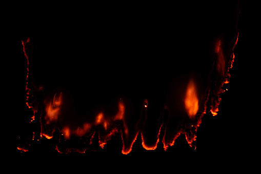 burning paper, glowing edge of paper on a black background