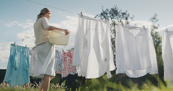 Assorted items of clothing drying on a clothes line, outdoors.