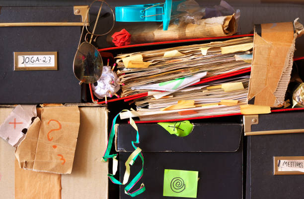 messy file folders and storage boxes in a cluttered office bookshelf,red tape, bureaucracy,aministration,business concept,free copy space.
