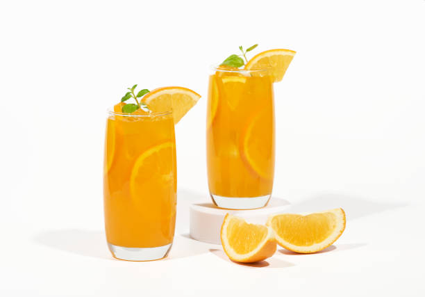 glass of 100% orange juice with orange slices fruits isolated on white background. cooling beverage summer drink - isolated on white orange juice ripe leaf foto e immagini stock