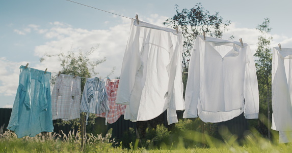 Wet clothes drying in the backyard of the house.