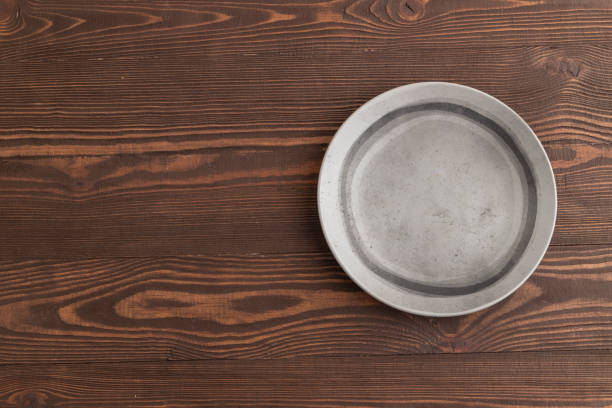 istock Empty gray ceramic plate on brown wooden background. Top view, copy space 2004991996