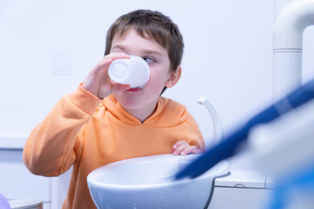 istock Boy rinsing his teeth at the dentist's office 2004994658