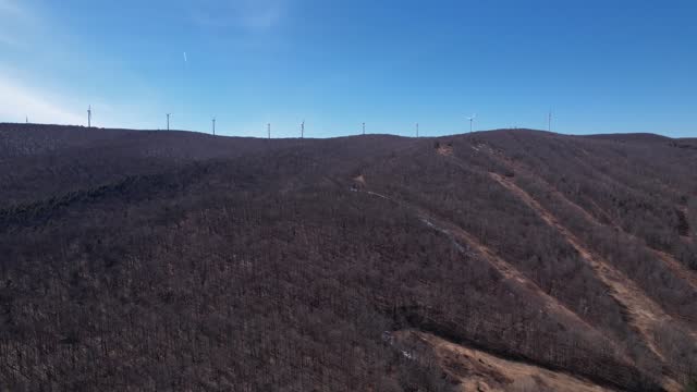 A scenic view of windmill and ski runs in Lanesborough, MA, showcasing renewable energy and winter sport facilities.