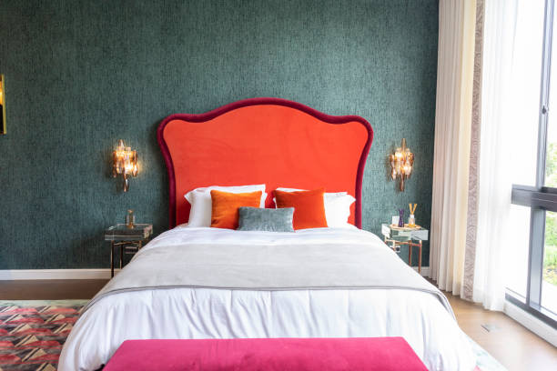 istock Modern luxurious red tone bed with crystal wall lamp in interior. 2005001070