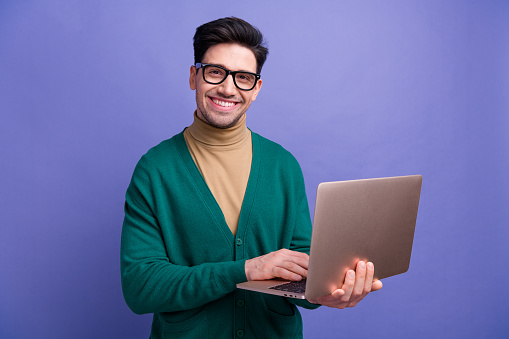 Photo of handsome cheerful man wear stylish green outfit use netbook macbook wifi connection isolated on purple color background