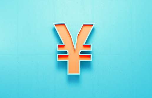 Orange Yen sign on blue concrete wall background. Horizontal composition.