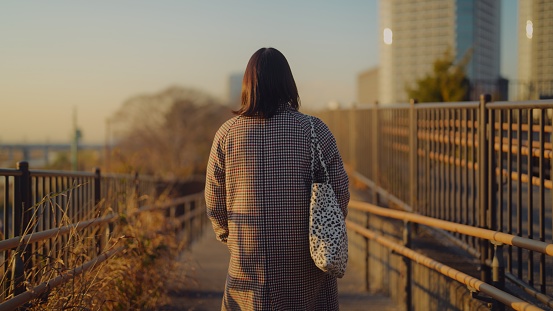 A woman is escaping from city life and spending time in nature during sunset.
