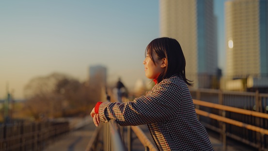 A woman is escaping from city life and spending time in nature during sunset.