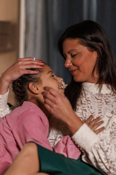 istock Mother and daughter relaxing on the sofa and cuddling 2005045075