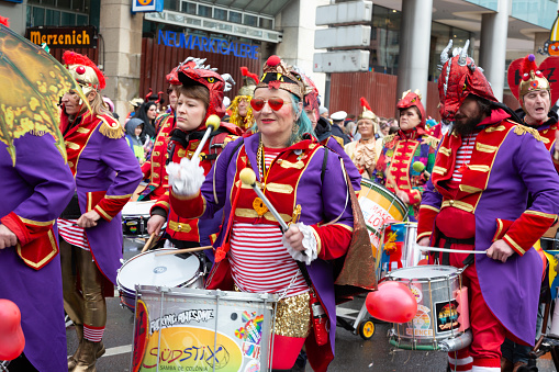 Cologne, Germany - February 11, 2024: On Carnival Sunday in Cologne, there are the traditional parades of schools and societies, Schull- un Veedelszöch the participants are usually wearing self made costumes,  here a marching band wearing colorful costumes