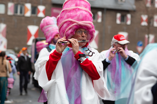 Cologne, Germany - February 11, 2024: On Carnival Sunday in Cologne, there are the traditional parades of schools and societies, Schull- un Veedelszöch)( the participants are usually wearing self made costumes, here member of Spielmannszug Möhnesee Körbeckeplaying the flute, they are together with the group of the Apostelgymnasium