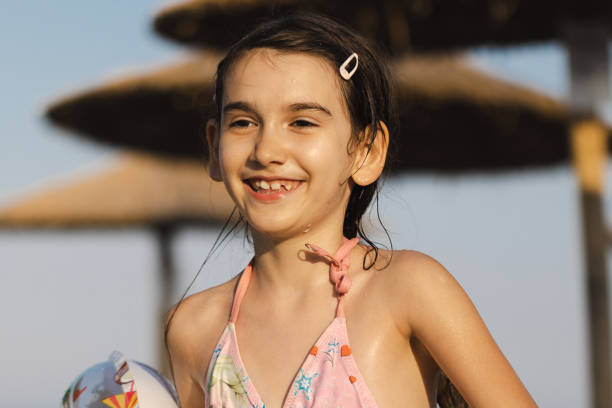One young girl sitting on the beach.