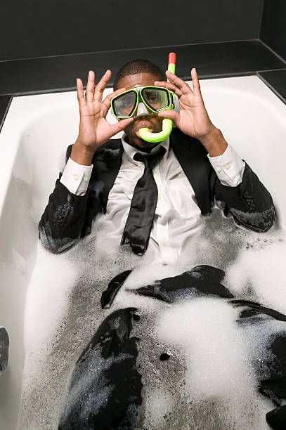 young man in suit and snorkel sitting in bubble bath - annabelle foto e immagini stock