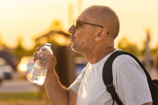 istock Man drinking water at the beach 2005079586