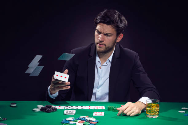 istock Addiction Concepts. Angry Depressed Handsome Caucasian Brunet Pocker Player At Pocker Table With Chips and Cards Drinking Alcohol And Throwing Cards Away. 2005080140