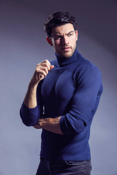 istock One Handsome Caucasian Brunet Businessman Wearing Sweater Posing With Folded Hands Looking Aside Against Gray Background. 2005090049