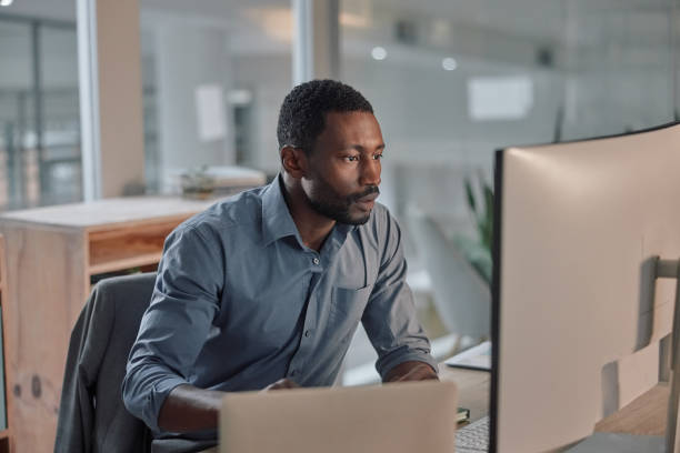 istock Black man, serious and computer in office for online research and digital planning on technology. IT consultant, connection and productivity on internet for business and reading of project on website 2005096435