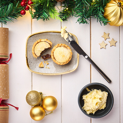 Christmas, pie and decoration on table, above and holiday with food for lunch, celebration or festive in home. Meal, diet and nutrition with knife, butter and cracker for tradition, culture and party