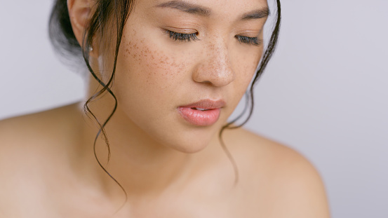 Calm, skincare and Asian woman in studio for cosmetic, wellness or treatment on grey background. Face, care and Japanese female model relax with natural beauty, shine of glowing skin dermatology