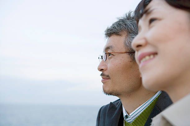 mature couple, with sea in background, close-up, side view - 僅日本人 圖片 個照片及圖片檔