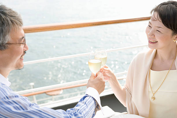 Mature couple toasting on deck of cruise ship, smiling  drinks on the deck stock pictures, royalty-free photos & images
