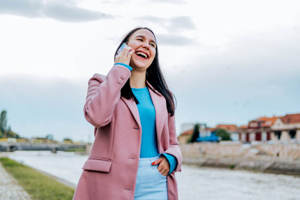 istock Young woman making a call outdoors 2005144414